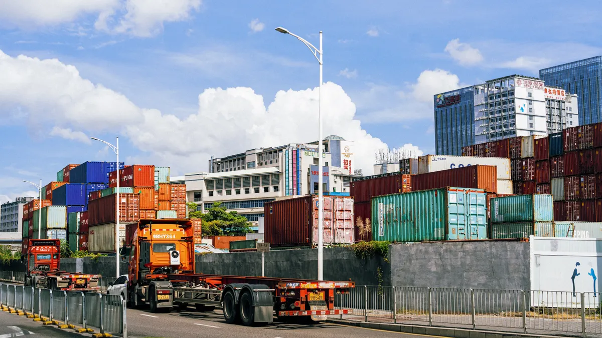 Colorful shipping containers stack at an industrial port under clear skies.