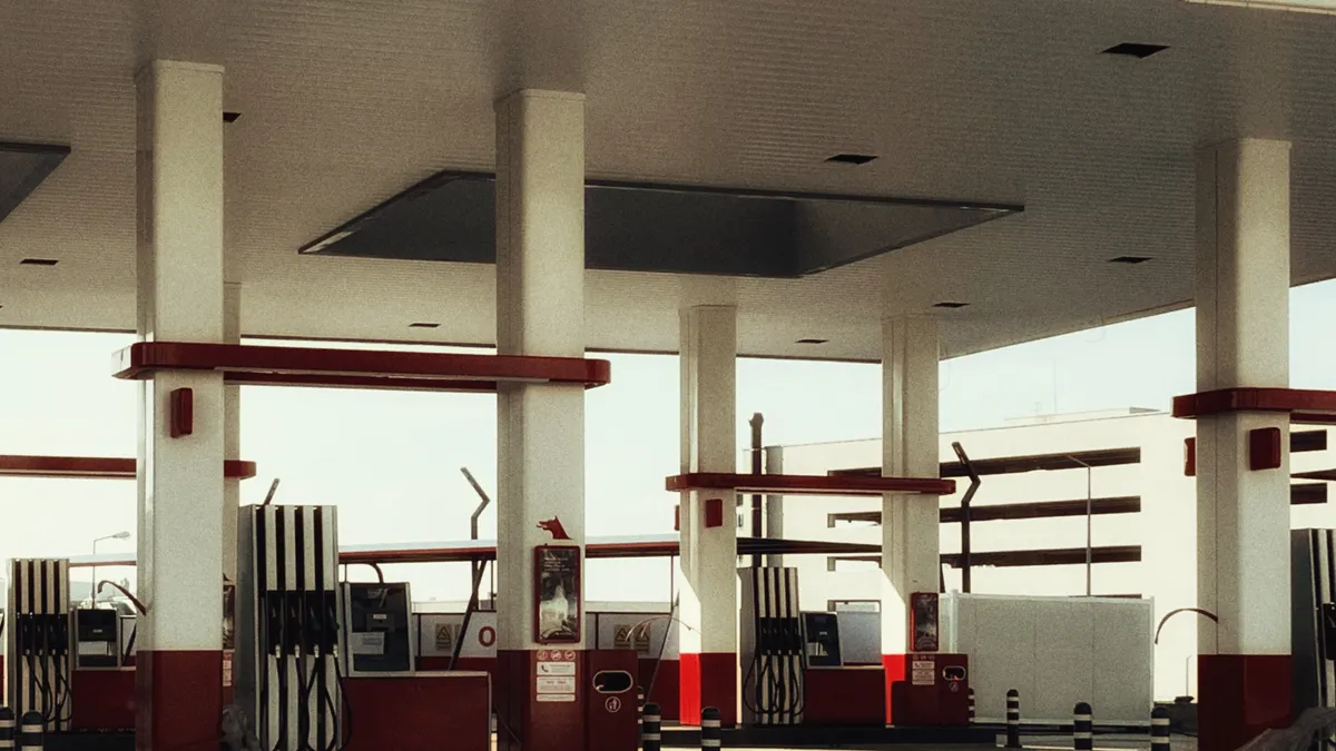Brightly lit modern gas station featuring multiple fuel pumps and a distinct red and white design.