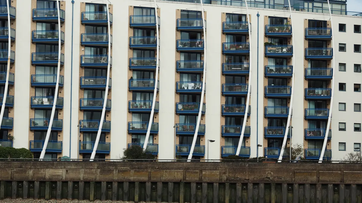 Contemporary apartment block with blue balconies and unique facade design.