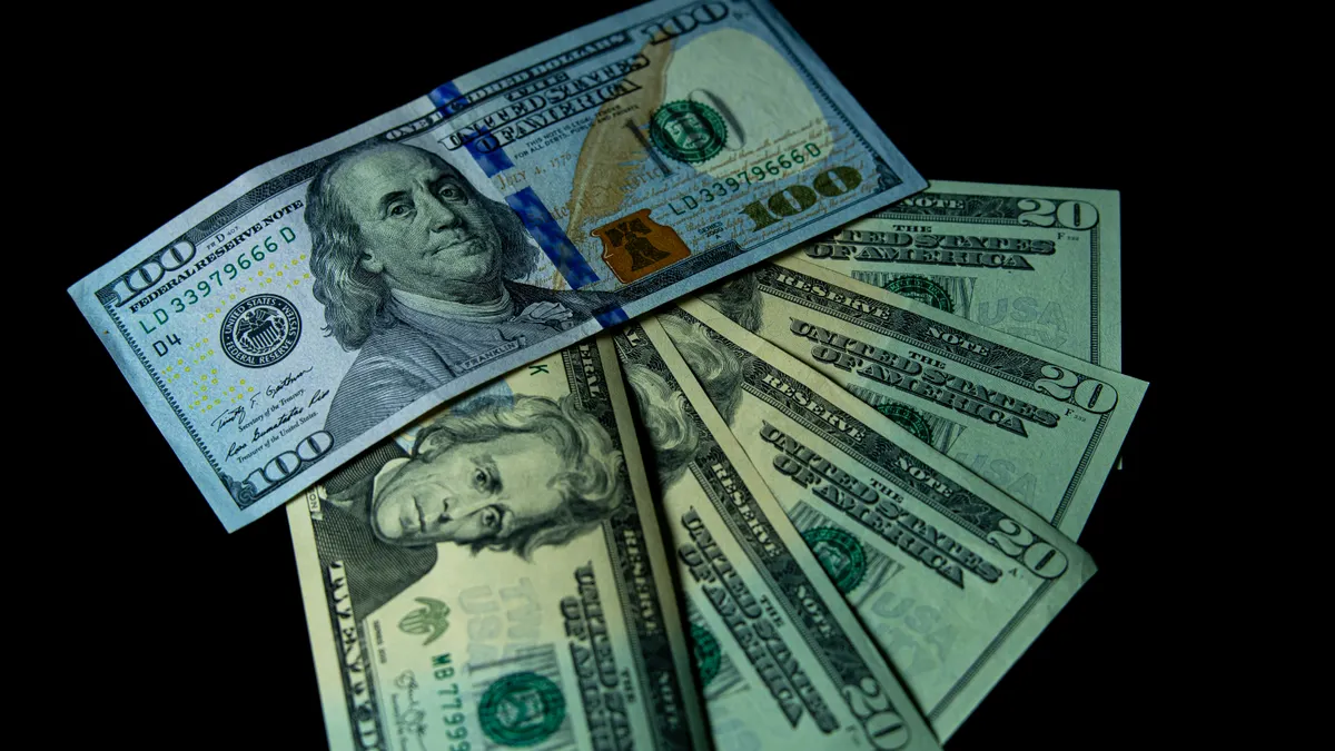 Close-up image of varied US dollar bills on a black background.