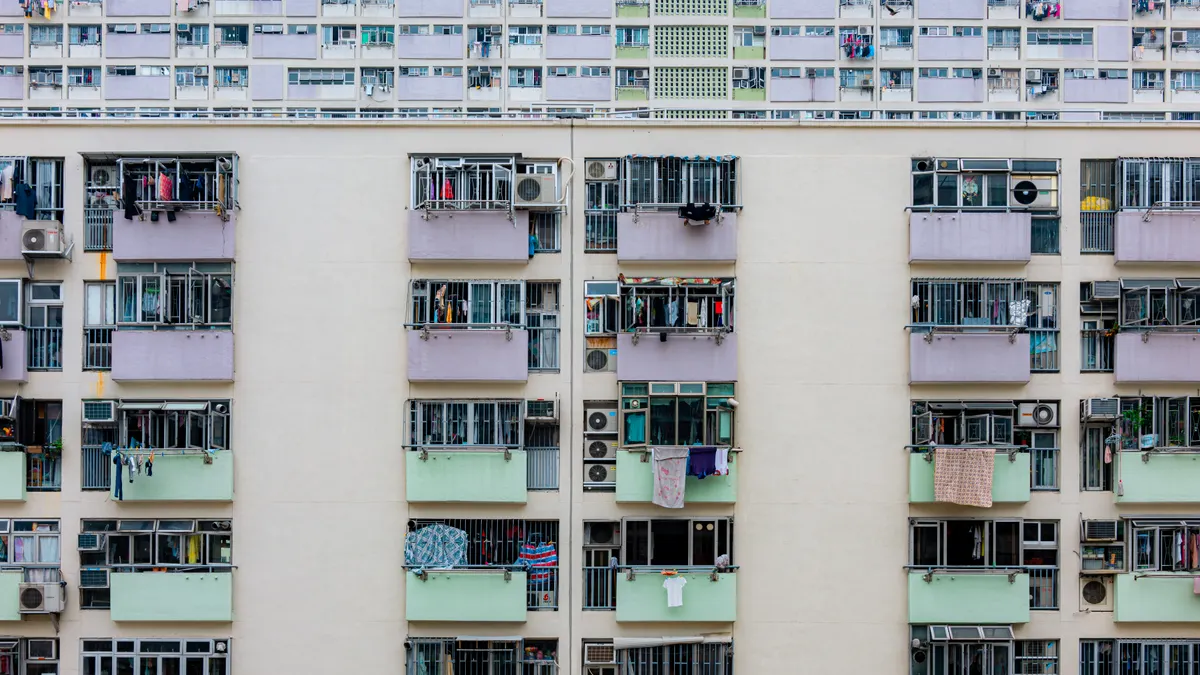Multicolored urban apartment building with balconies and windows, showcasing city living.