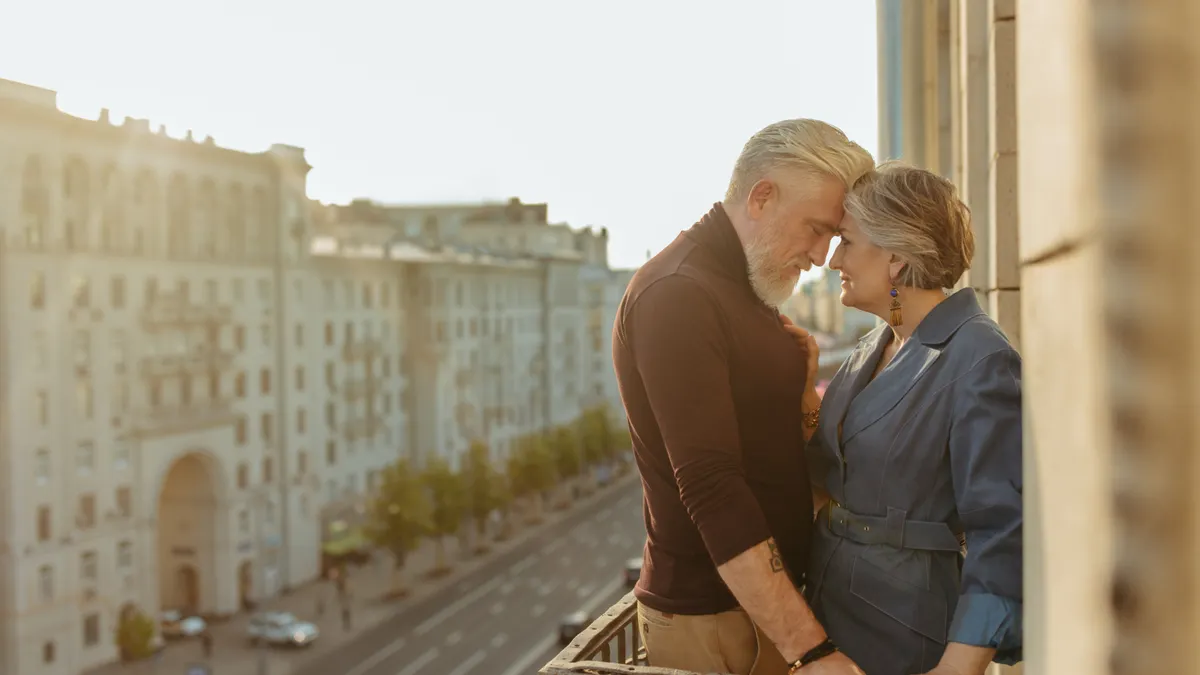 Senior couple enjoying a romantic moment on a city balcony, showcasing love and connection.