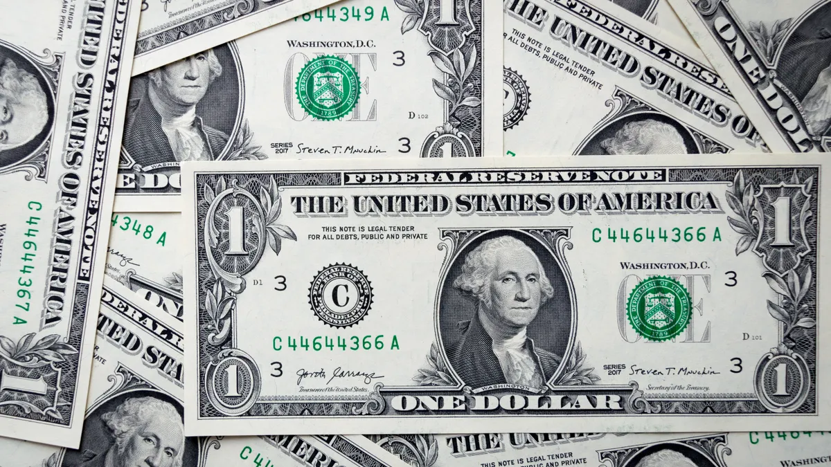 Detailed close-up of multiple one dollar bills showcasing U.S. currency design.